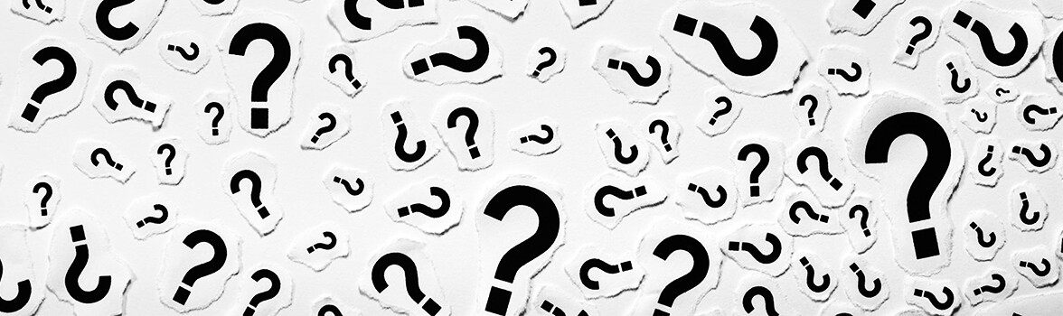 Białe tło i czarne znaki zapytania.