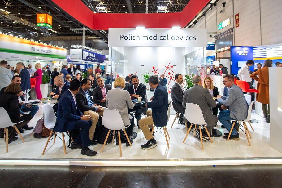 ludzie w hali targowo-wystawienniczej siedzą przy stolikach