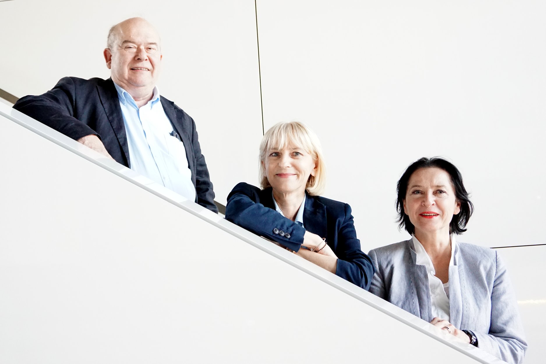 tr&oacute;jka młodych ludzi w średnim wieku: od lewej mężczyzna, a obok niego dwie kobiety, blondynka i brunetka