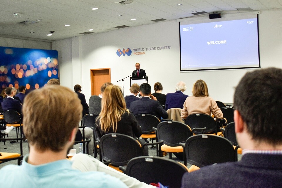 Ludzie siedzący na sali patrzą na osobę przemawiającą z m&oacute;wnicy