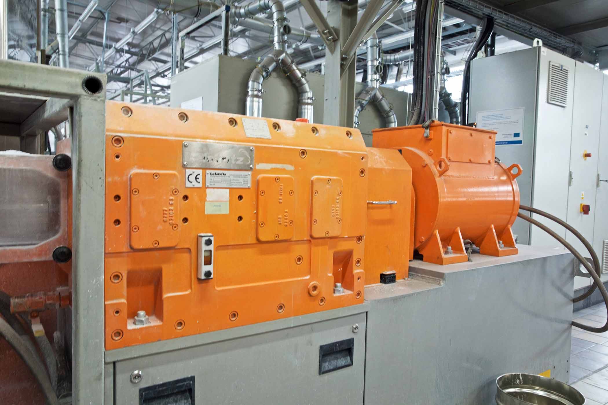 Zdjęcie pomarańczowej maszyny produkcyjnej w hali