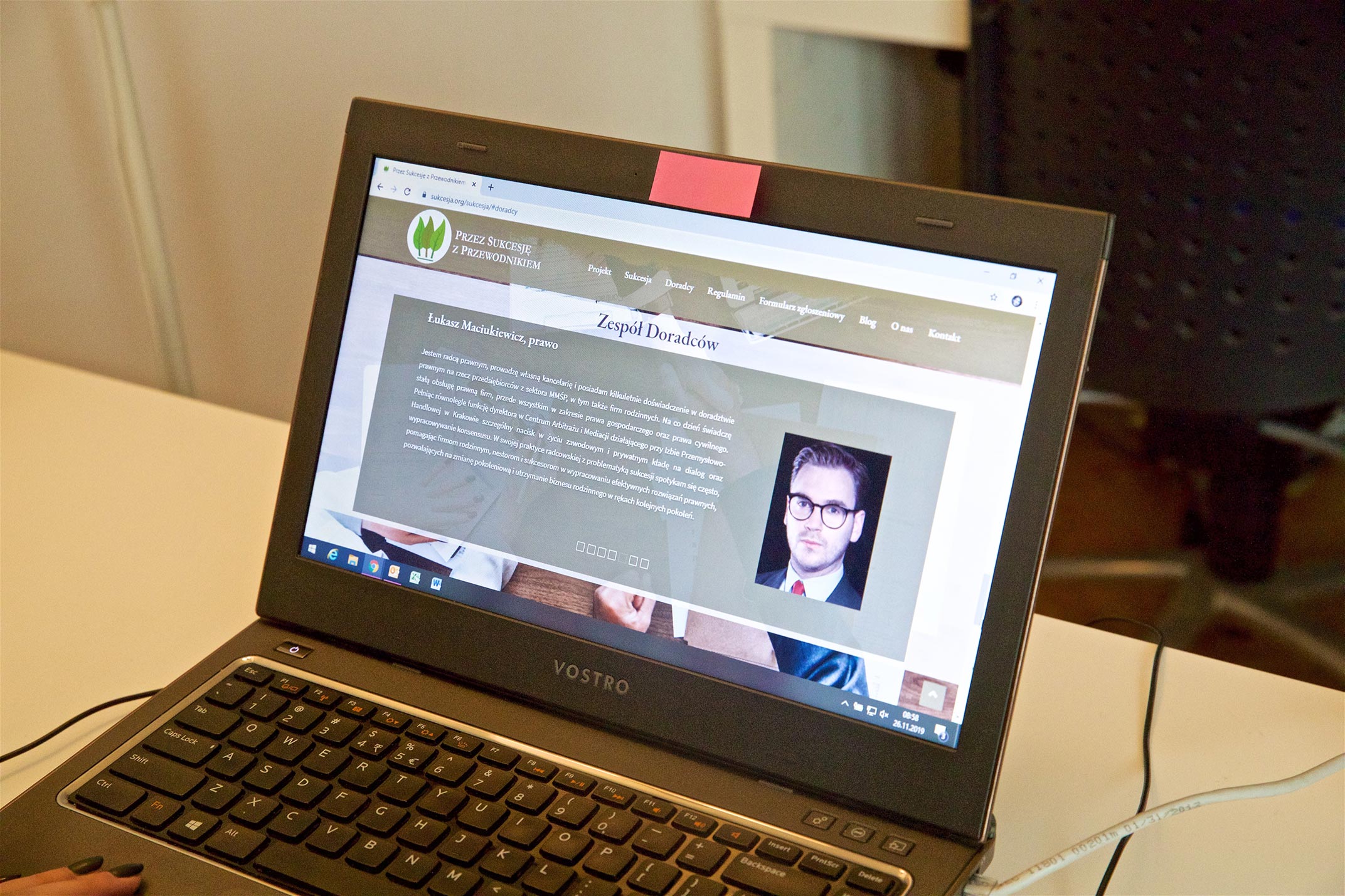 Laptop, na kt&oacute;rym widać stronę internetową Przez sukcesję z przewodnikiem