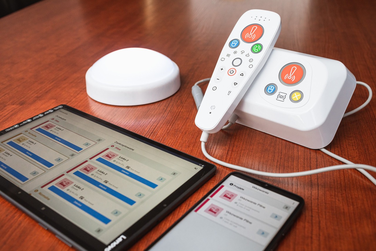 Na blacie leżą tablet, telefon i urządzenie