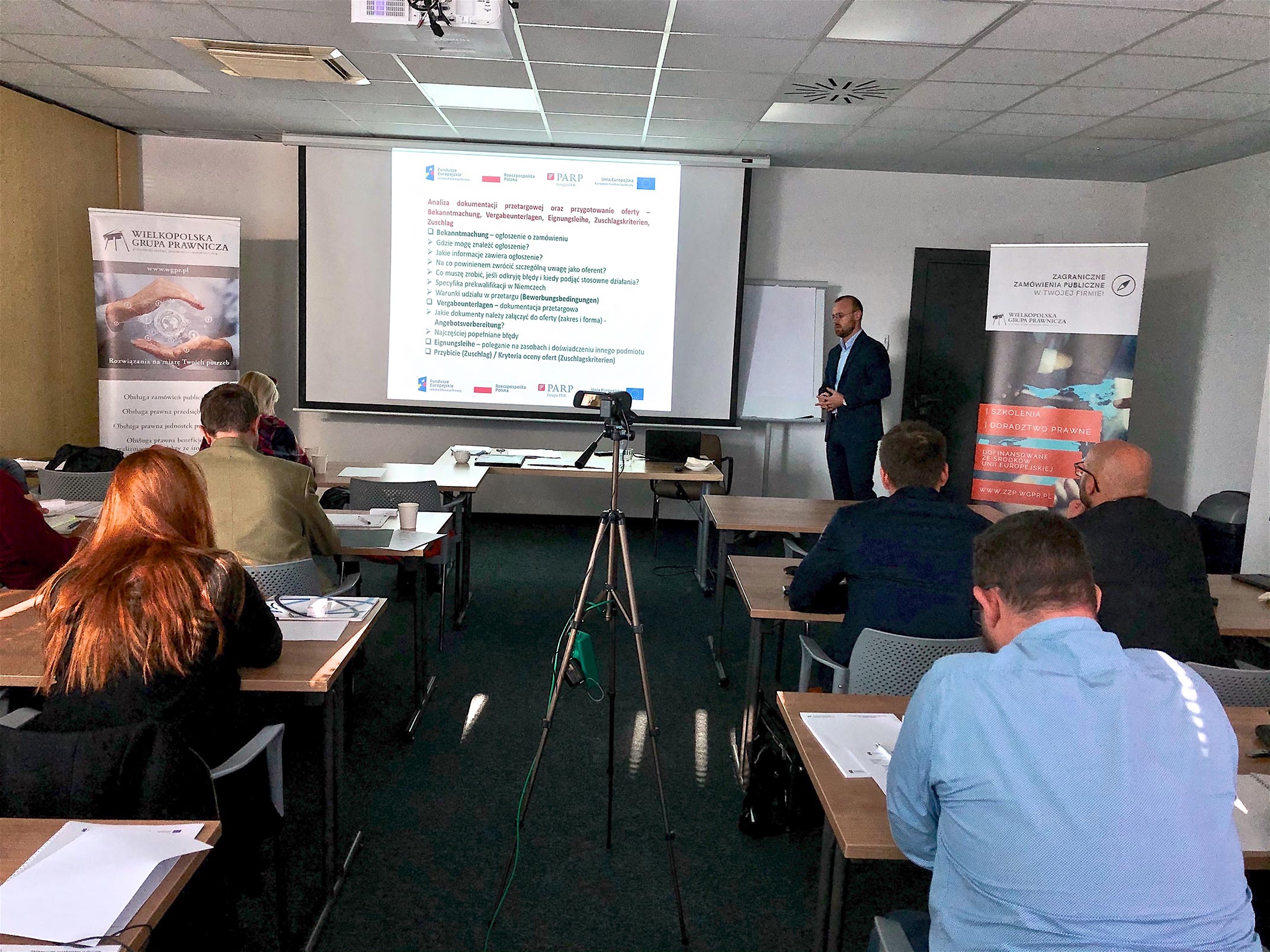 Widok katalogu informacyjnego "Zam&oacute;wienia publiczne" z ulotką oraz notesem położone na blacie biurka